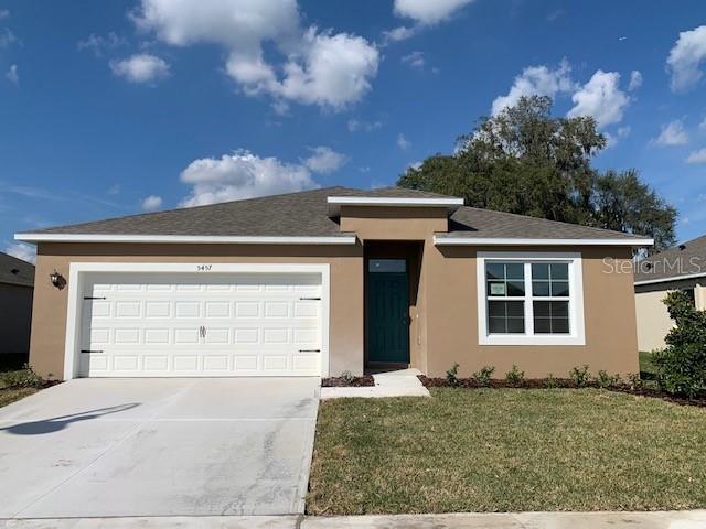 view of front of property with a garage and a front lawn