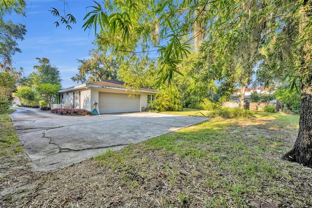 view of side of home featuring a lawn and a garage