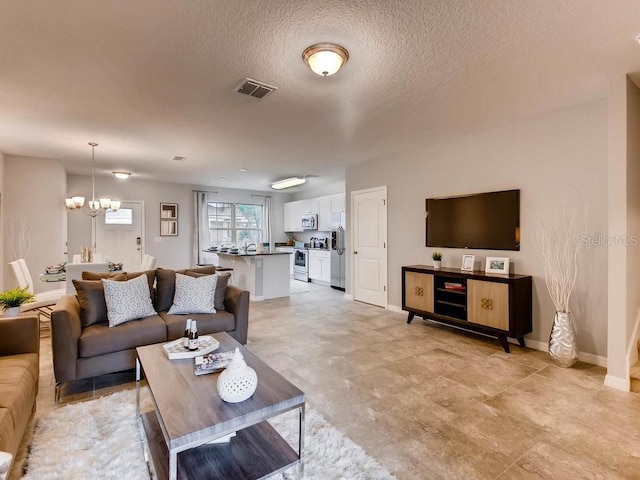 living room featuring a textured ceiling and a chandelier