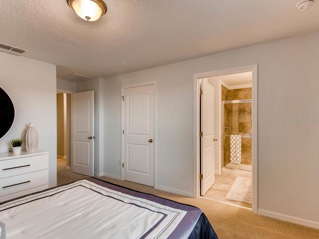 unfurnished bedroom with a textured ceiling, light carpet, ensuite bathroom, and a closet