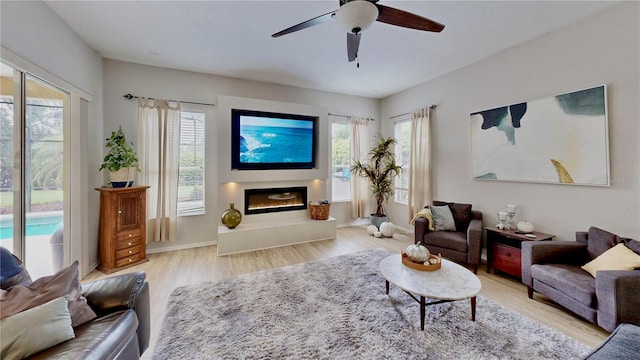 living room with ceiling fan, light hardwood / wood-style floors, and a wealth of natural light