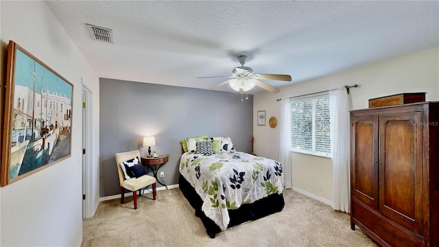 carpeted bedroom featuring ceiling fan and a textured ceiling