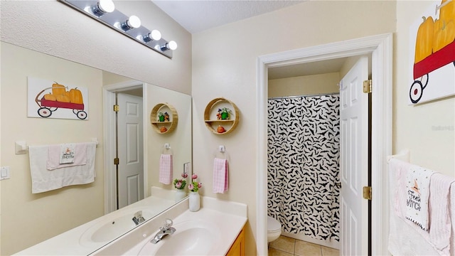 bathroom with tile patterned floors, vanity, toilet, and curtained shower