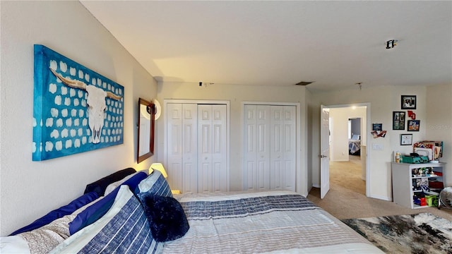 carpeted bedroom featuring multiple closets