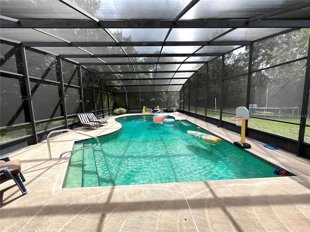 view of pool with glass enclosure and a patio area