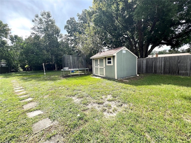 view of yard featuring a trampoline and a storage unit