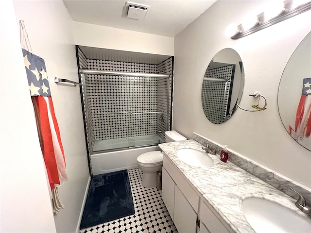 full bathroom with bath / shower combo with glass door, vanity, and toilet