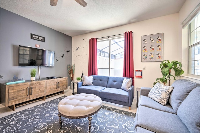 living room with ceiling fan and a textured ceiling