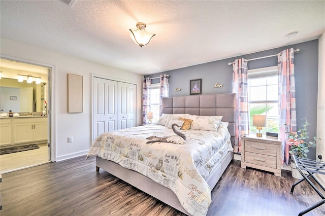 bedroom with dark hardwood / wood-style flooring, a closet, multiple windows, and a textured ceiling