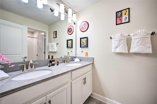 bathroom with vanity, a textured ceiling, tile patterned flooring, and a shower with shower door