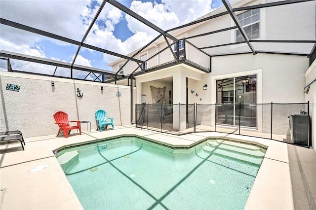 view of pool with a patio and glass enclosure