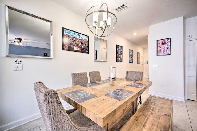 tiled dining space with ceiling fan with notable chandelier and a textured ceiling