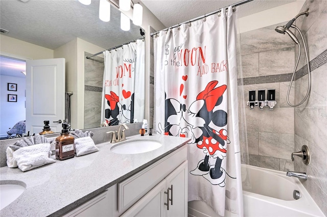 bathroom with shower / bath combo, vanity, and a textured ceiling