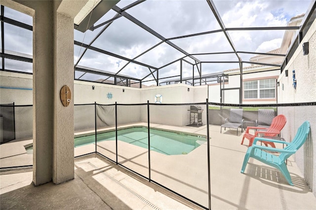 view of swimming pool with glass enclosure and a patio