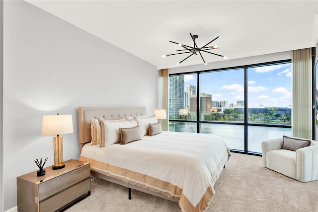 carpeted bedroom with a view of city, access to outside, a chandelier, and a wall of windows