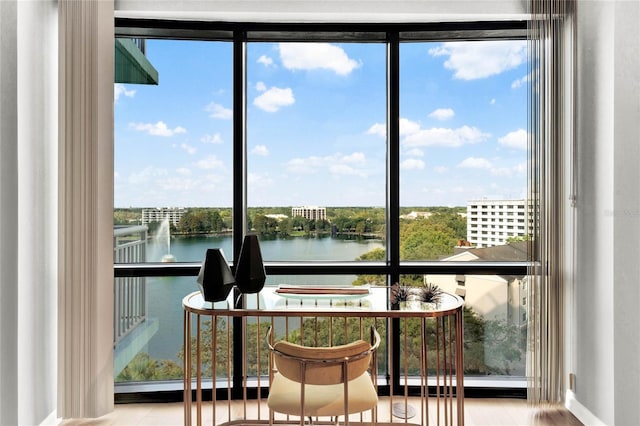 sunroom / solarium with a water view and wood finished floors
