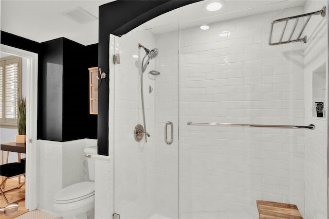 bathroom with tile patterned floors, an enclosed shower, and toilet