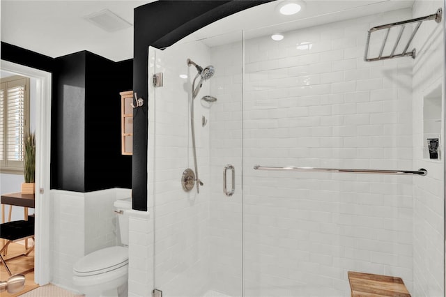 bathroom featuring toilet, visible vents, and a shower stall