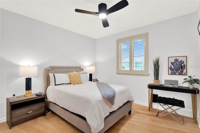 bedroom featuring a ceiling fan, baseboards, and light wood-style floors