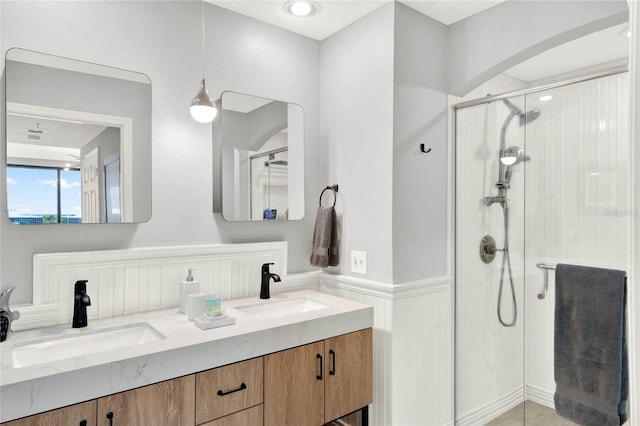 bathroom featuring tile patterned flooring, a shower with shower door, and vanity