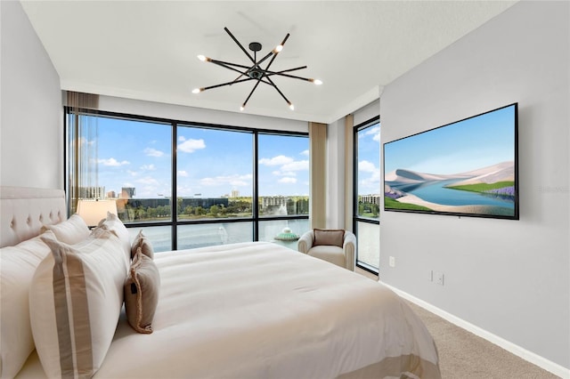 carpeted bedroom with baseboards, a notable chandelier, and access to exterior