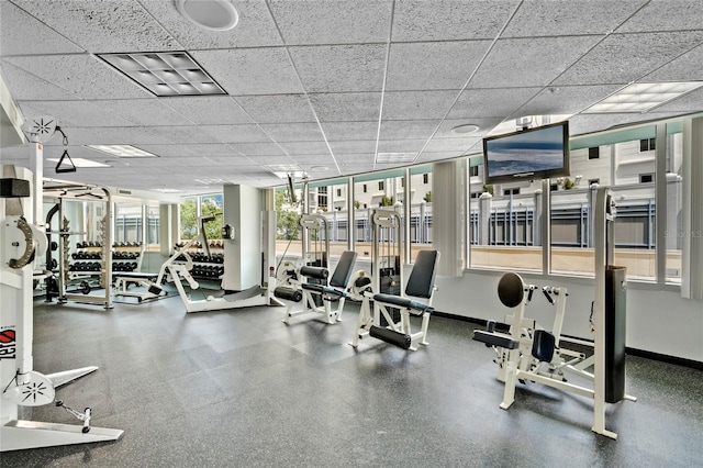 gym with baseboards and a drop ceiling