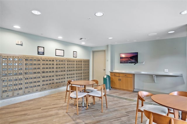 dining space featuring light wood-type flooring and mail boxes