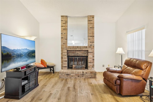 living room featuring light hardwood / wood-style floors and a brick fireplace