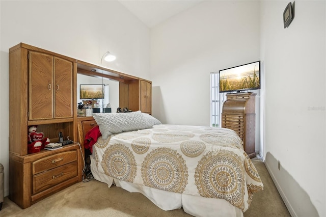 carpeted bedroom with high vaulted ceiling