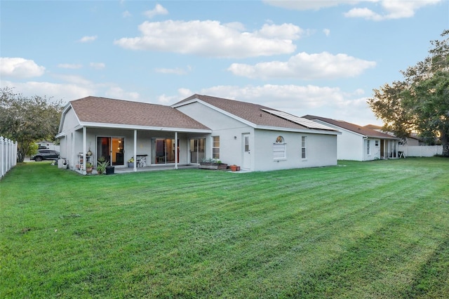 back of house with a patio area and a lawn