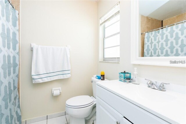 bathroom featuring toilet, vanity, tile patterned floors, and curtained shower