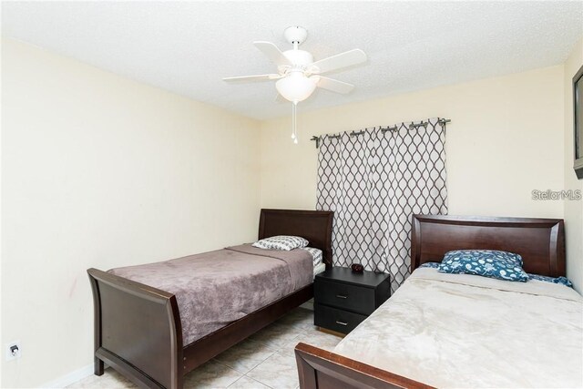 tiled bedroom featuring ceiling fan