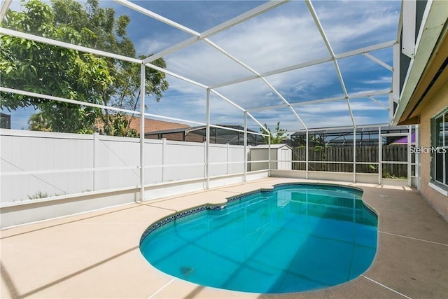 view of pool with a patio, a lanai, and a storage shed