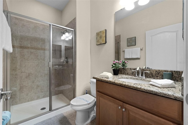 bathroom featuring vanity, tile patterned flooring, toilet, and a shower with shower door