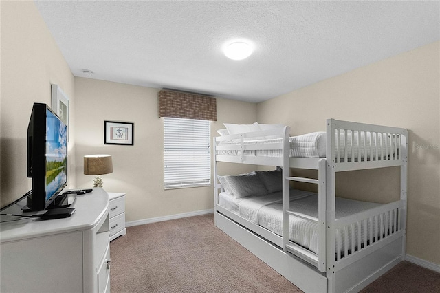 bedroom with a textured ceiling and light colored carpet