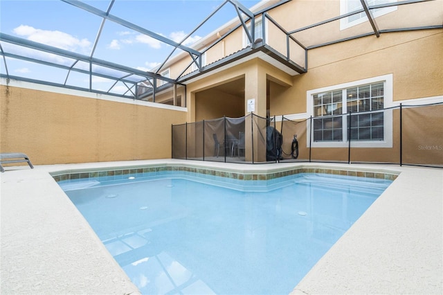 view of swimming pool featuring glass enclosure