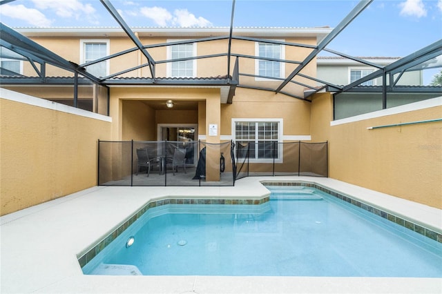 view of pool with glass enclosure and a patio