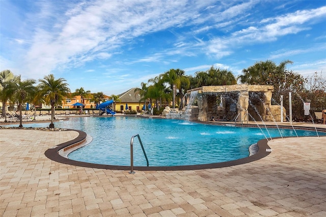 view of pool with a water slide and pool water feature