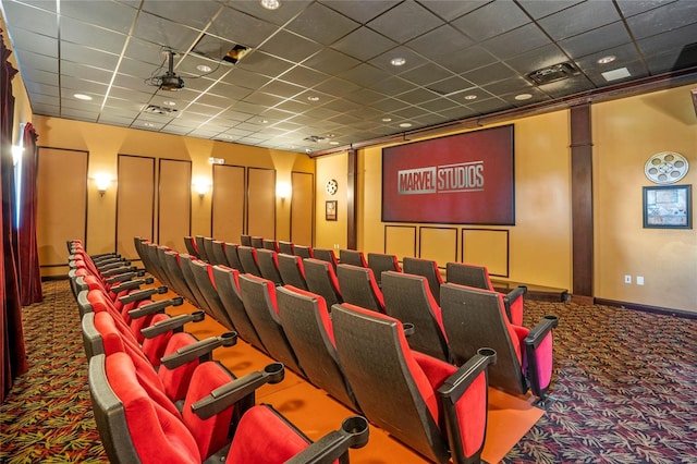 carpeted cinema room featuring a drop ceiling