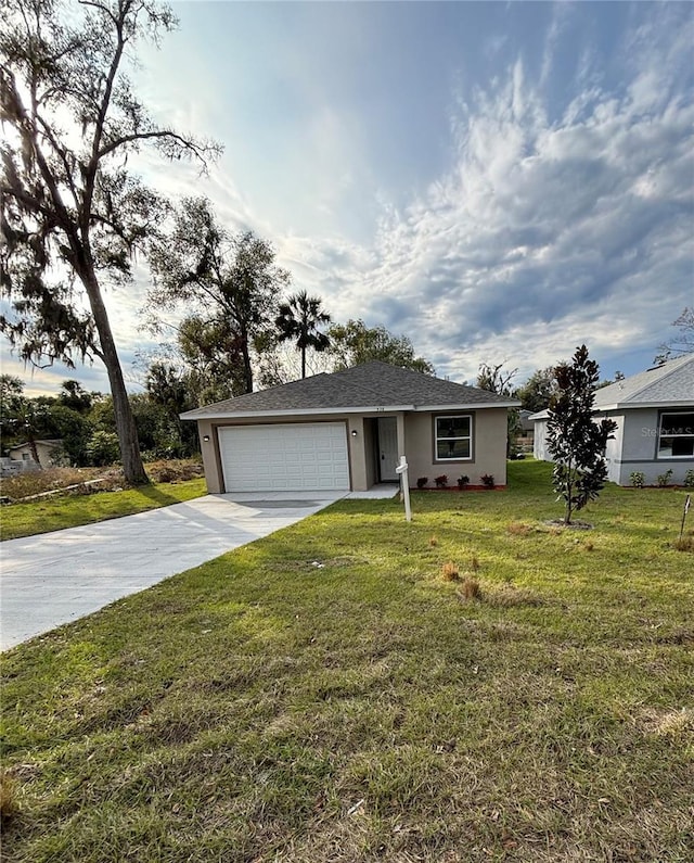 single story home with a garage and a front lawn