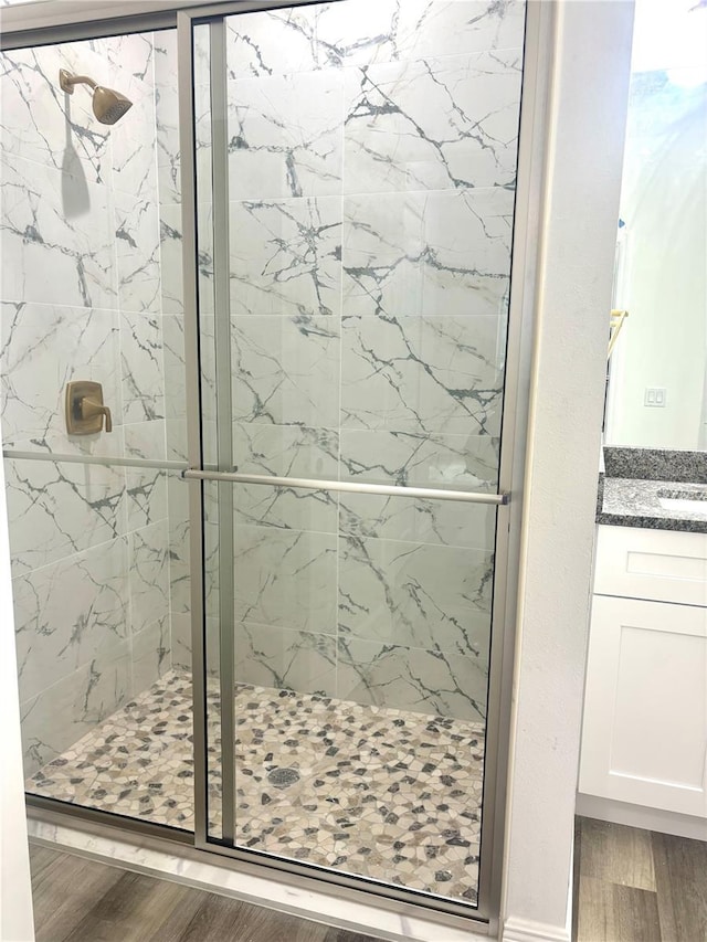 bathroom featuring hardwood / wood-style floors, an enclosed shower, and vanity