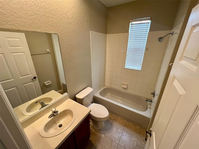 full bathroom with tile patterned flooring, tiled shower / bath combo, vanity, and toilet