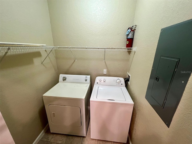 washroom featuring light tile patterned flooring, electric panel, and washer and dryer