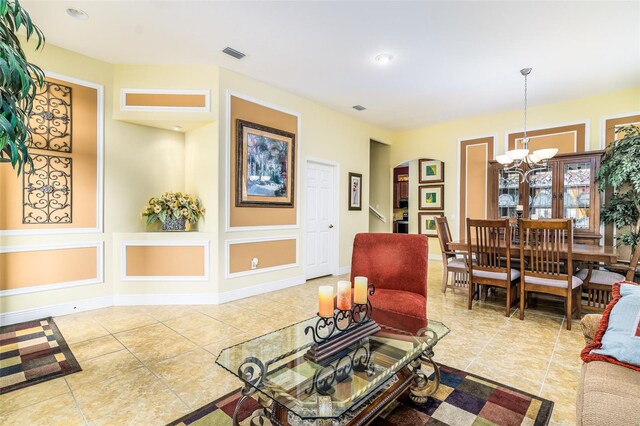 living room featuring a notable chandelier and tile patterned flooring