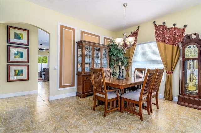 tiled dining area featuring ceiling fan with notable chandelier