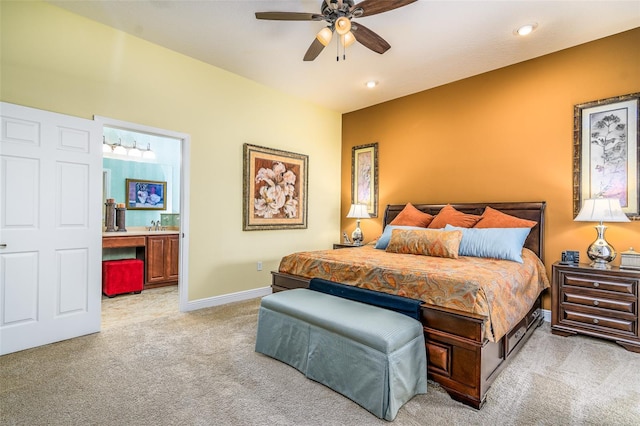 carpeted bedroom featuring ceiling fan, sink, and ensuite bath