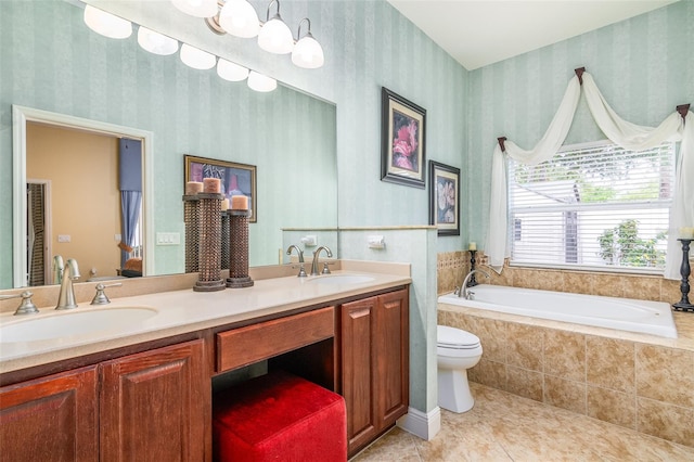 bathroom featuring tile patterned floors, a relaxing tiled tub, vanity, and toilet