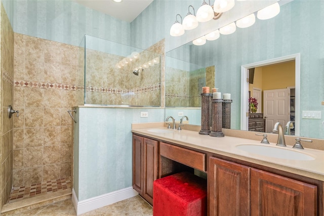 bathroom with a tile shower, tile patterned flooring, and vanity