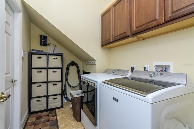 washroom featuring separate washer and dryer and cabinets