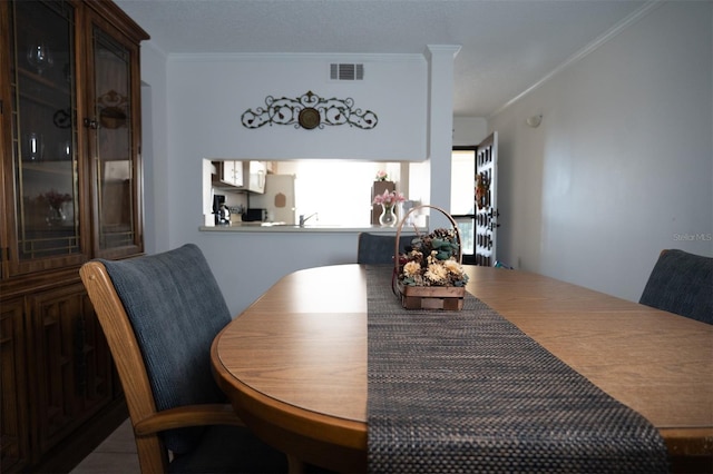 dining space with crown molding and visible vents